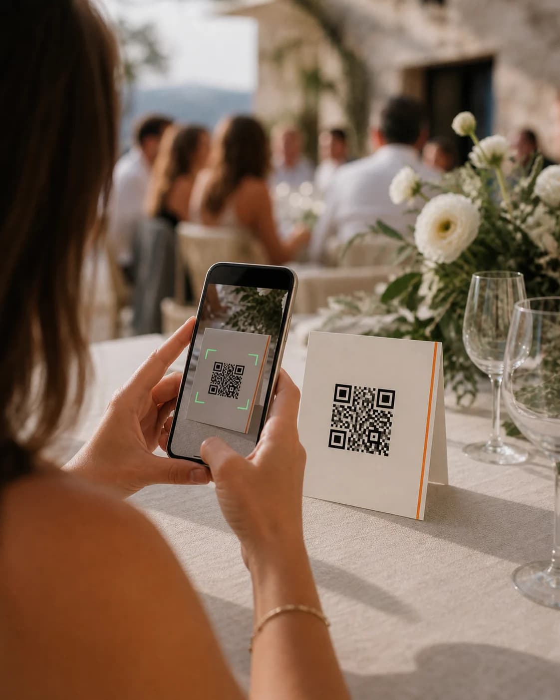 Düğün masasında QR kodlu albüm kartını telefon kamerasıyla okutan bir misafir